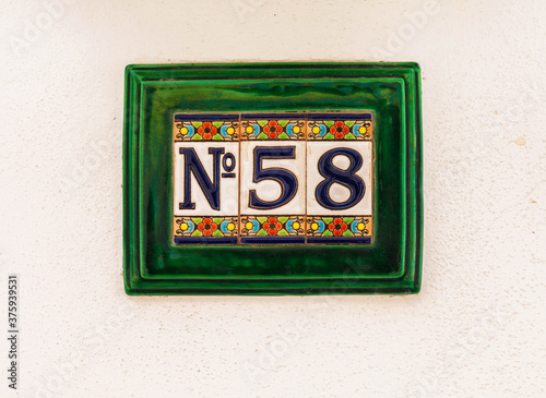 Decorative ceramic house number 58 tile on the wall, characteristic decorative element
