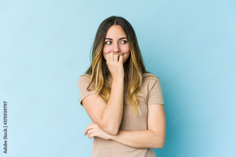 Young caucasian woman isolated on blue background biting fingernails, nervous and very anxious. Young caucasian woman isolated on blue background biting fingernails, nervous and very anxious.