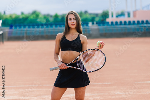 Beautiful stylish sexy woman in black trendy sportswear on tennis court. holding tennis racket © Ivan Zelenin