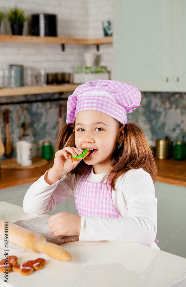 Girl in the kitchen kneads dough for glazed gingerbread Girl in the kitchen kneads dough for glazed gingerbread