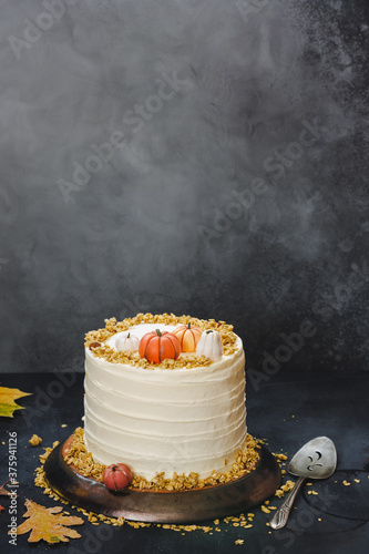 Pumpkin pie layer cake with brown sugar and  cream cheese frosting on rustic table  with autumnal decoration. Selective focus, copy space