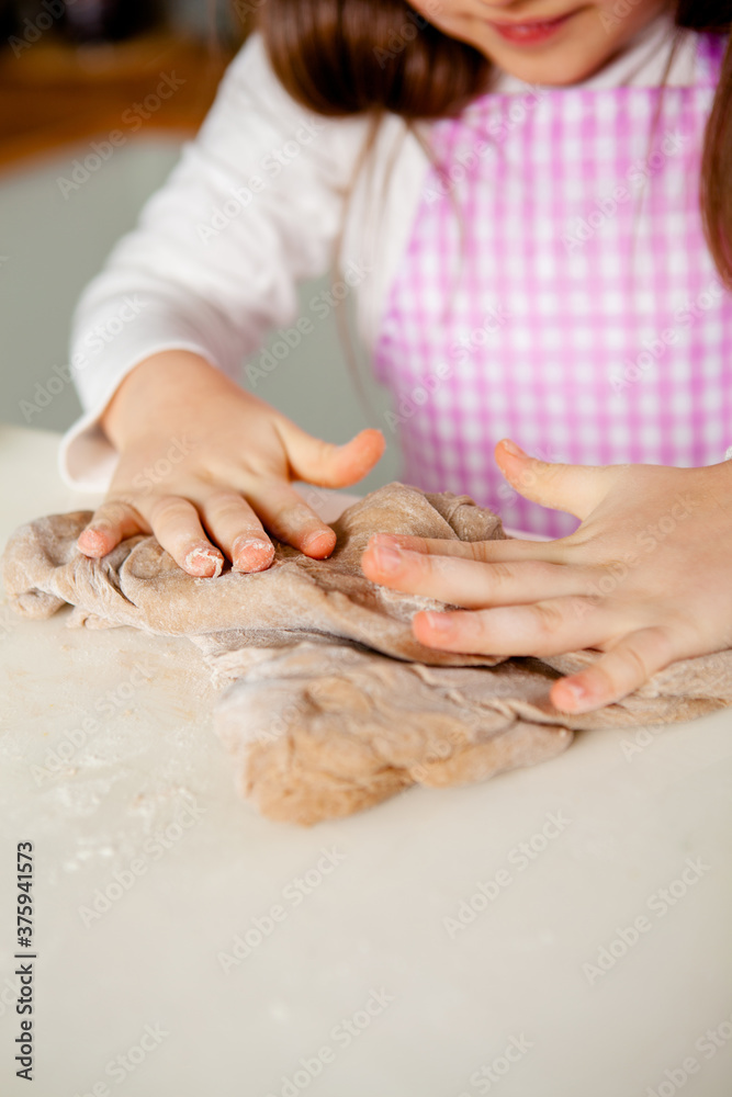 child's fingers knead the dough for gingerbread