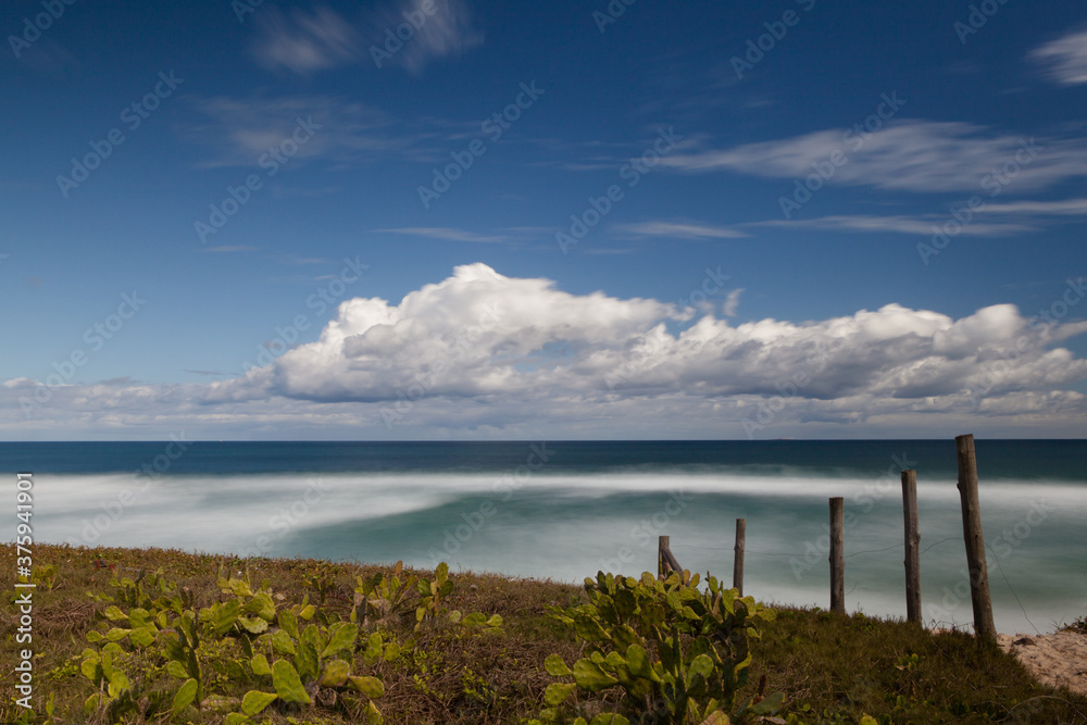 Green sea, blue sky and white clouds. Ecological reserve Recreio dos Bandeirantes, Rio de Janeiro, Brazil 