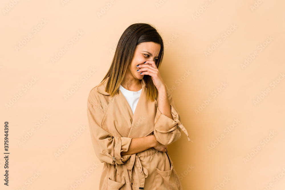 Young woman isolated on beige background laughing happy, carefree, natural emotion. Young woman isolated on beige background laughing happy, carefree, natural emotion.