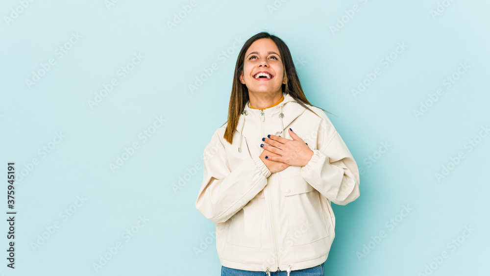 Young woman isolated on blue background laughing keeping hands on heart, concept of happiness. Young woman isolated on blue background laughing keeping hands on heart, concept of happiness.