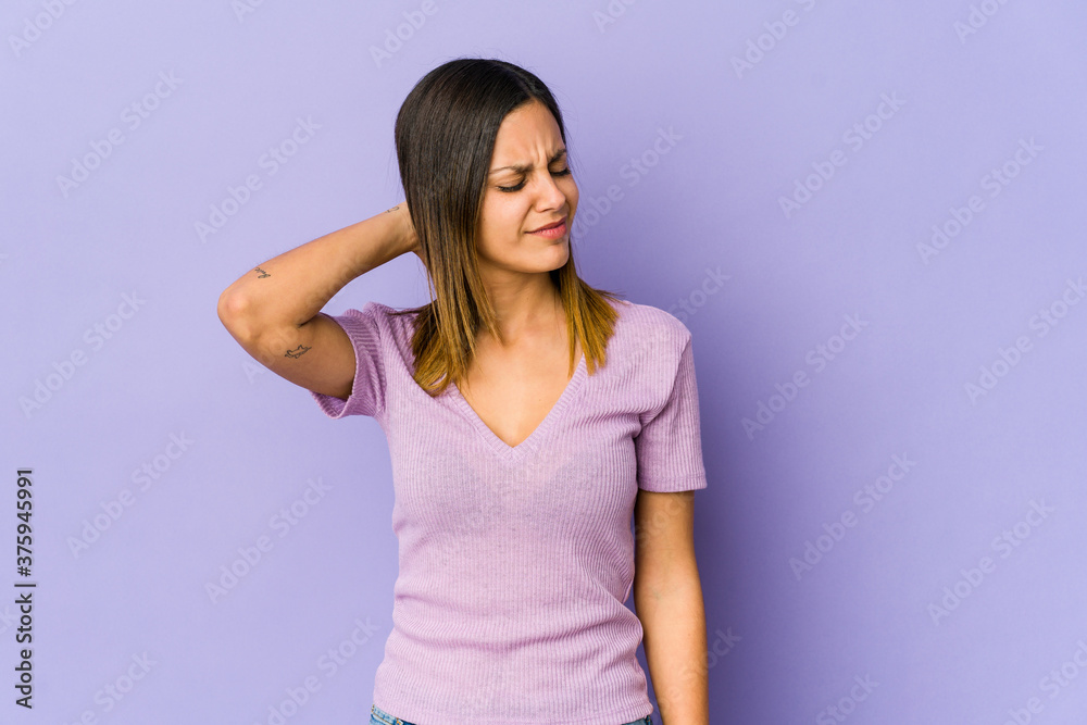 Young woman isolated on purple background suffering neck pain due to sedentary lifestyle. Young woman isolated on purple background suffering neck pain due to sedentary lifestyle.
