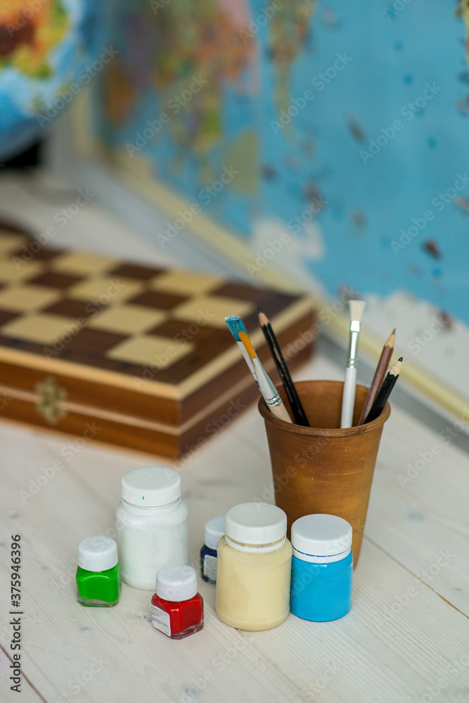 Obraz premium Brushes for drawing on a table with a globe. Schoolboy's Desk . Back to school.