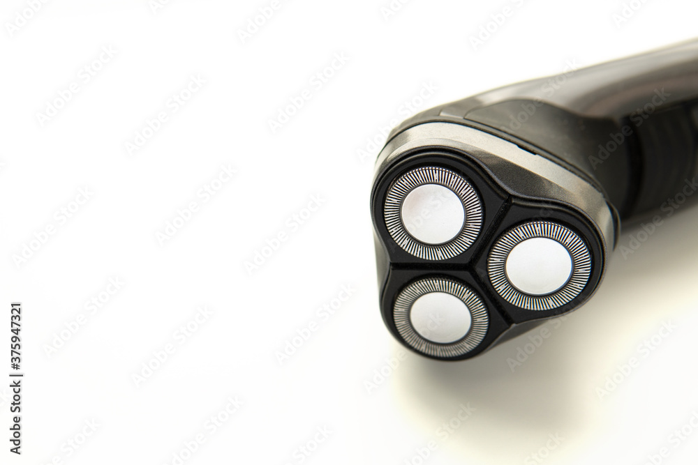 Men's electric rotary shaver isolated on white background. Close up photo of an electric razor laying sideways. Men's electric rotary shaver isolated on white background. Close up photo of an electric razor laying sideways.