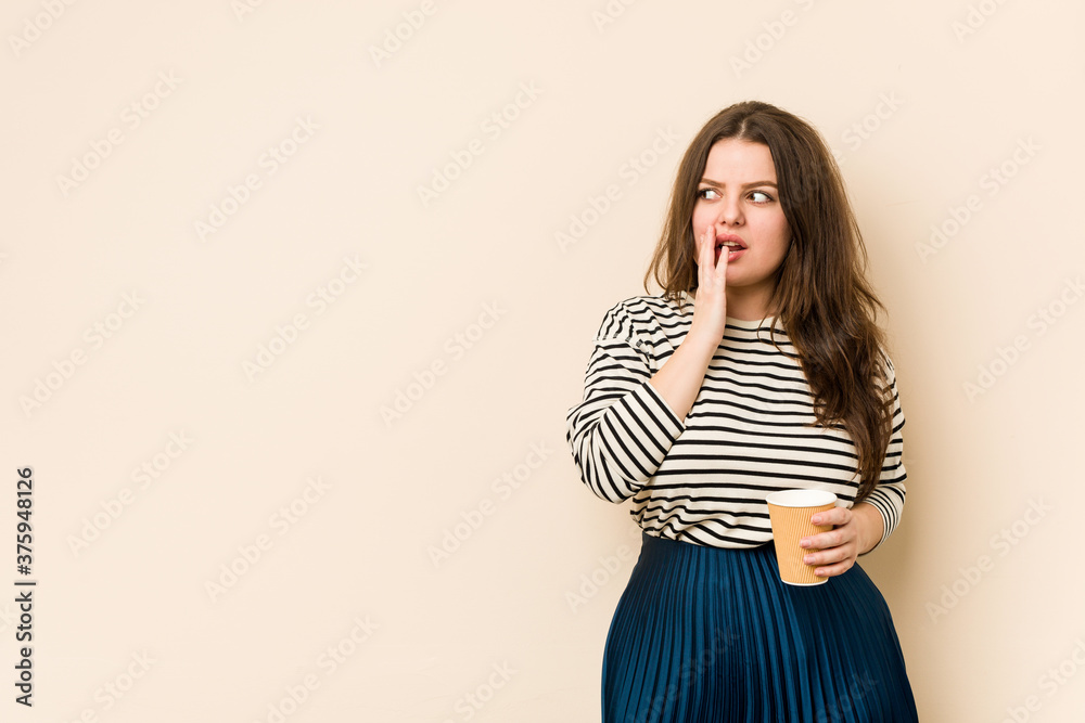 Young curvy woman holding a coffee is saying a secret hot braking news and looking aside Young curvy woman holding a coffee is saying a secret hot braking news and looking aside