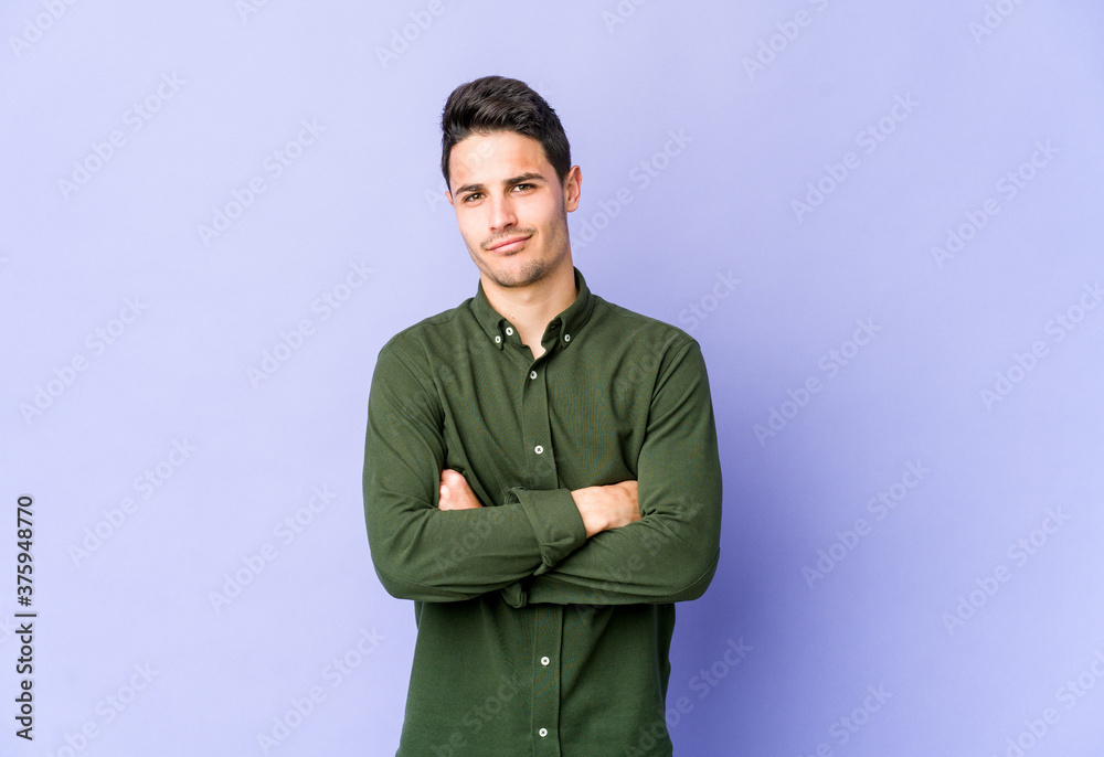 Young caucasian man isolated on purple background frowning face in displeasure, keeps arms folded. Young caucasian man isolated on purple background frowning face in displeasure, keeps arms folded.