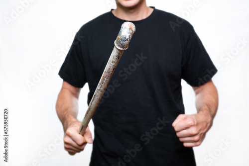 piece of pipe in the hand of an aggressive man, close-up, selective focus.