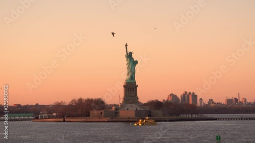 Statue of Liberty with the city skyline in the background. A view from the cruise ship while it's sailing in the Hudson River