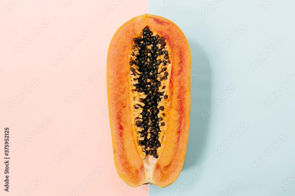 Papaya on a pastel pink blue background, creative food concept, tropical fruit. Flat lay. Top view. Tropical travel, exotic fruit. Vegan and vegetarian concept Papaya on a pastel pink blue background, creative food concept, tropical fruit. Flat lay. Top view. Tropical travel, exotic fruit. Vegan and vegetarian concept
