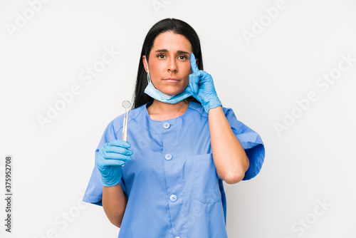 Dentist woman isolated on white background pointing temple with finger  thinking  focused on a task.