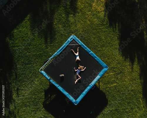 Aerial view of girls relaxing on trampoline