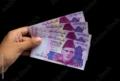 Pakistani 50 Note hold in hand, Isolated on black background