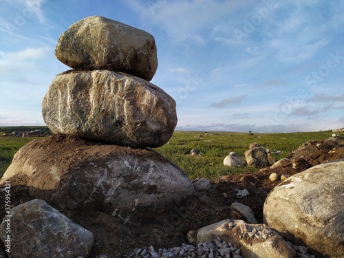 Pyramid of large stones in the middle of the tundra field photo