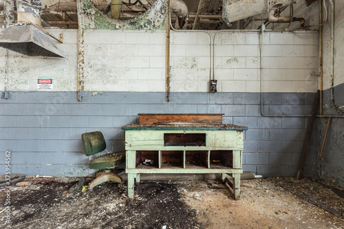 Empty green desk against block wall in abandoned factory in deep south