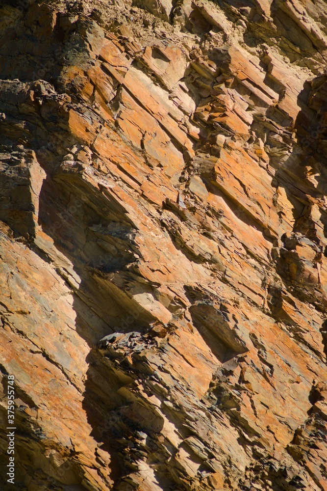 Obraz premium Reddish layered rock wall, with visible geological strata in the Andes mountains.