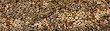 Wall of firewood, background of dry chopped firewood. Alternative fuel concept. Wide angle shot of natural background. Panoramic image in banner format.