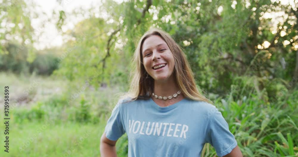 Caucasian woman smiling and looking at camera during river clean-up day Caucasian woman smiling and looking at camera during river clean-up day