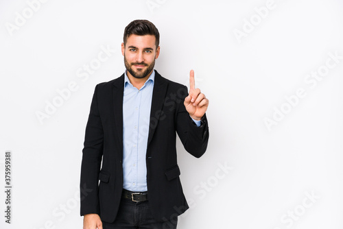 Young caucasian business man against a white background isolated showing number one with finger.