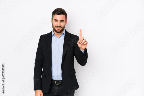 фотографія Young caucasian business man against a white background isolated showing number one with finger