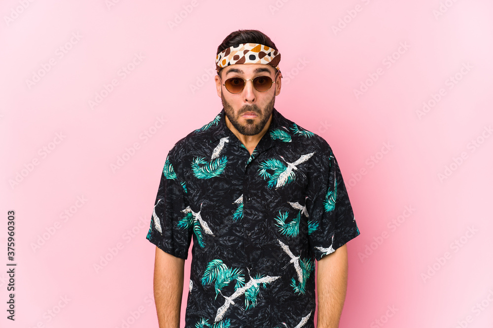 Young hipster man isolated shrugs shoulders and open eyes confused. Young hipster man isolated shrugs shoulders and open eyes confused.