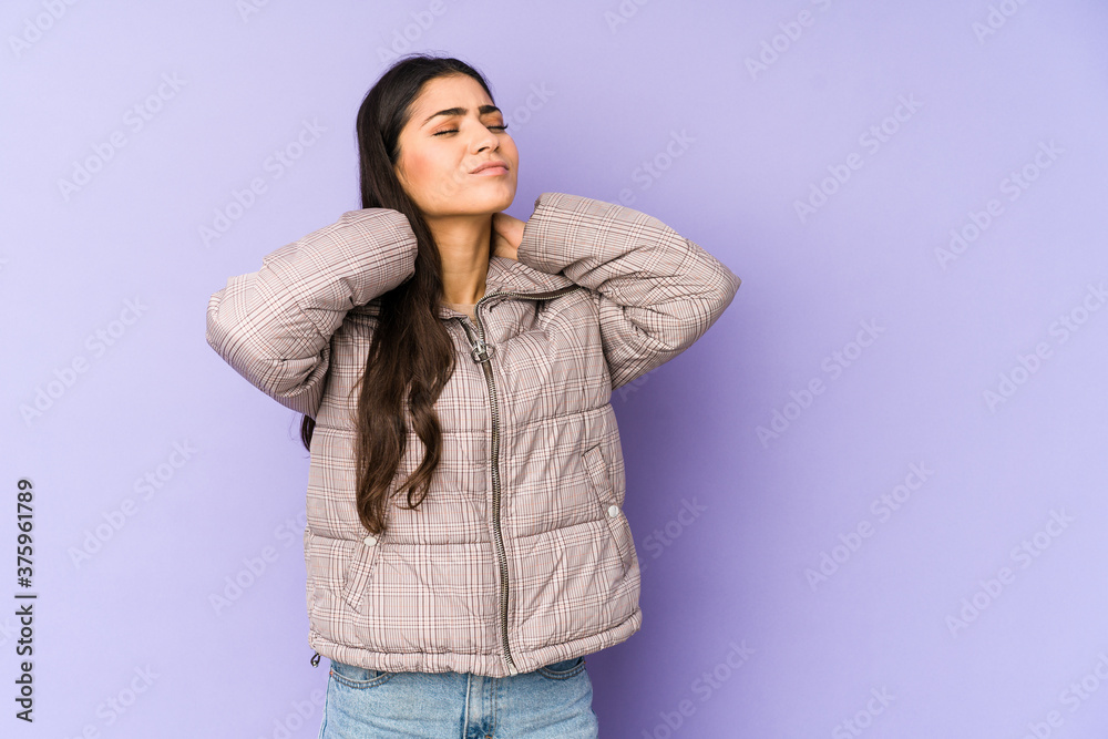 Young indian woman isolated on purple background suffering neck pain due to sedentary lifestyle. Young indian woman isolated on purple background suffering neck pain due to sedentary lifestyle.
