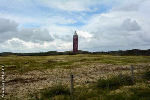 Westhoofd lighthouse in Ouddorp in the Netherlands  in a green landscape and a  barbed wire