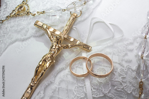 gold rings and cross on the wedding cushion