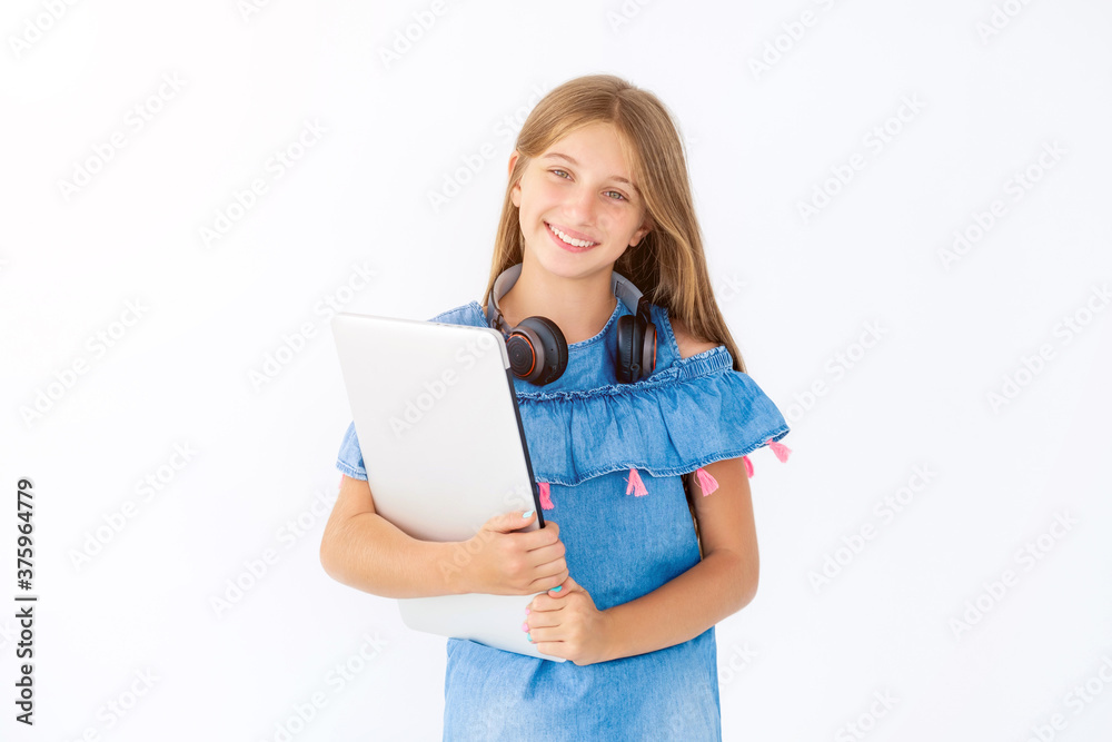 Happy girl with closed laptop and headphones around neck Happy girl with closed laptop and headphones around neck