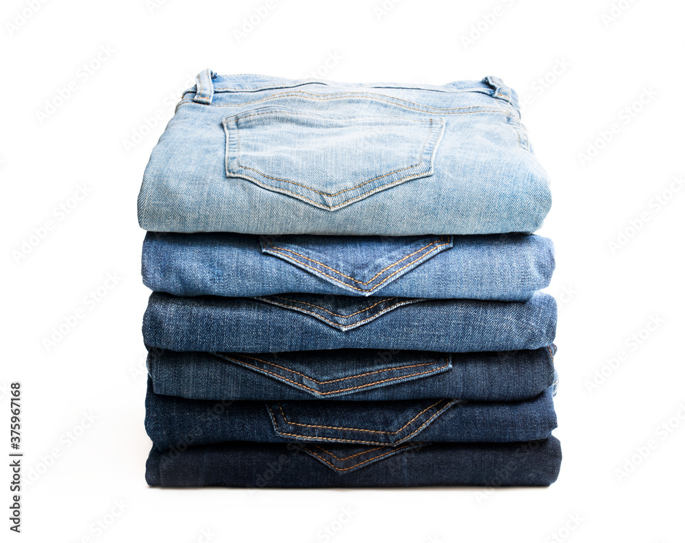 Lot of various used women jeans stacked in a pile isolated on white Lot of various used women jeans stacked in a pile isolated on white