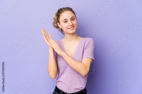 Young caucasian woman on purple background feeling energetic and comfortable, rubbing hands confident.