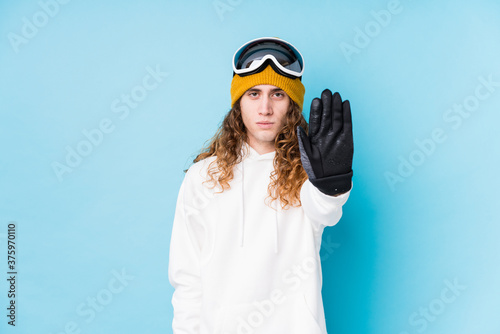 Young caucasian man wearing a ski clothes isolated standing with outstretched hand showing stop sign, preventing you.