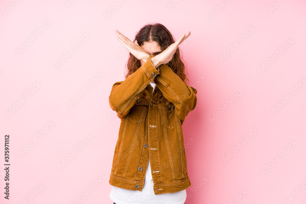 Young long hair man posing isolated keeping two arms crossed, denial concept.