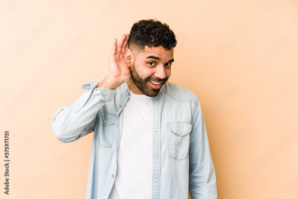 Young mixed race arabic man isolated trying to listening a gossip. Young mixed race arabic man isolated trying to listening a gossip.