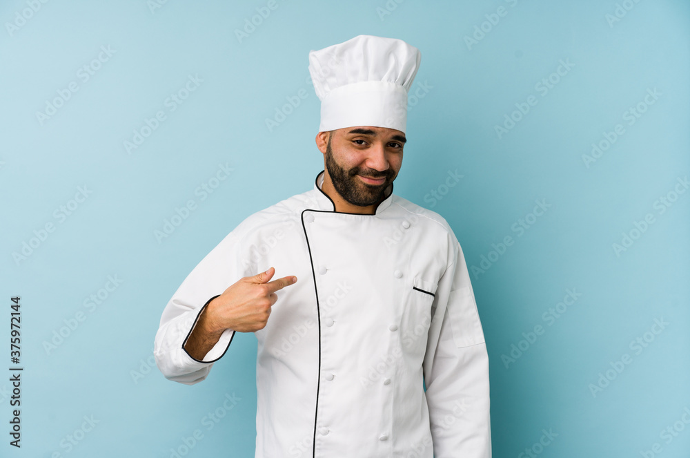 Young latin chef man isolated pointing with finger at you as if inviting come closer. Young latin chef man isolated pointing with finger at you as if inviting come closer.
