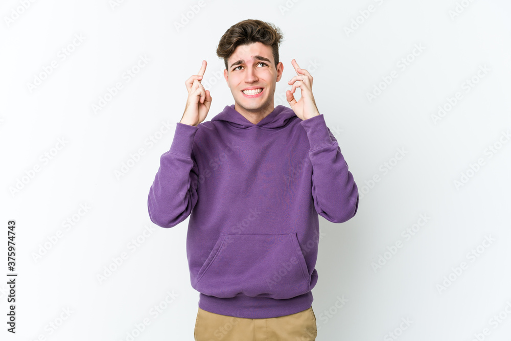 Young caucasian man isolated on white background crossing fingers for having luck Young caucasian man isolated on white background crossing fingers for having luck