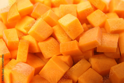 Cubes of fresh ripe carrots as background, closeup