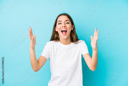 Young caucasian woman  isolated receiving a pleasant surprise, excited and raising hands.