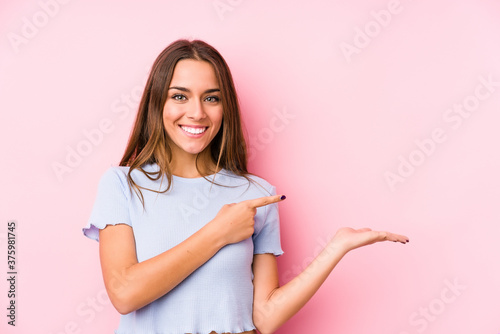 Young caucasian woman wearing a ski clothes isolated excited holding a copy space on palm.