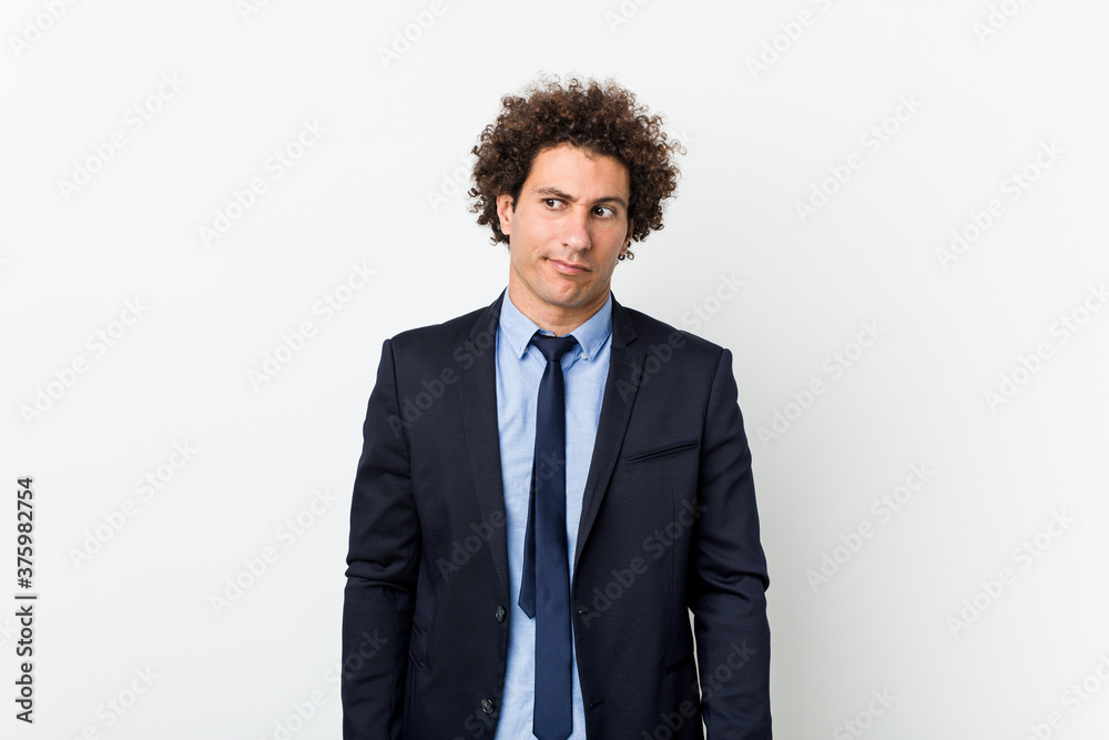 Young business curly man against white background confused, feels doubtful and unsure. Young business curly man against white background confused, feels doubtful and unsure.