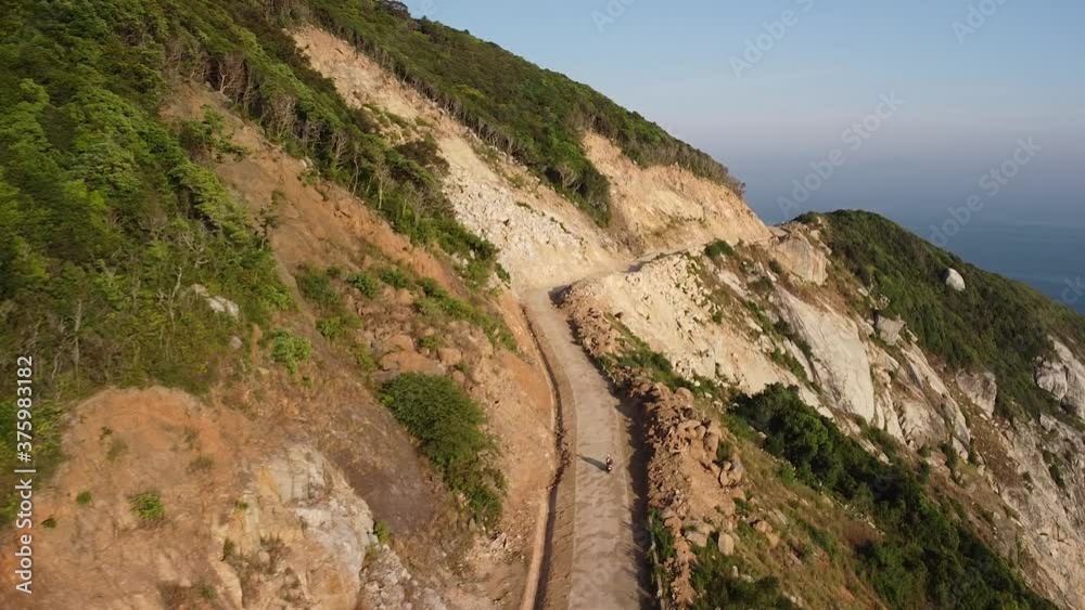 Drone flying over a breahtaking mountain island with road on cliffside. Drone flying over a breahtaking mountain island with road on cliffside.