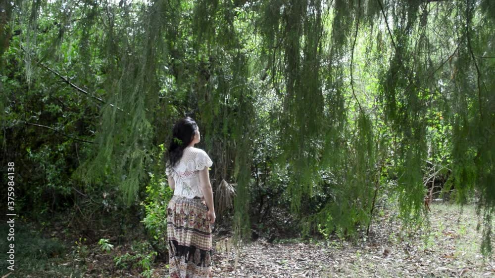 Hippie girl standing under a tree in a forest, american shot Hippie girl standing under a tree in a forest, american shot