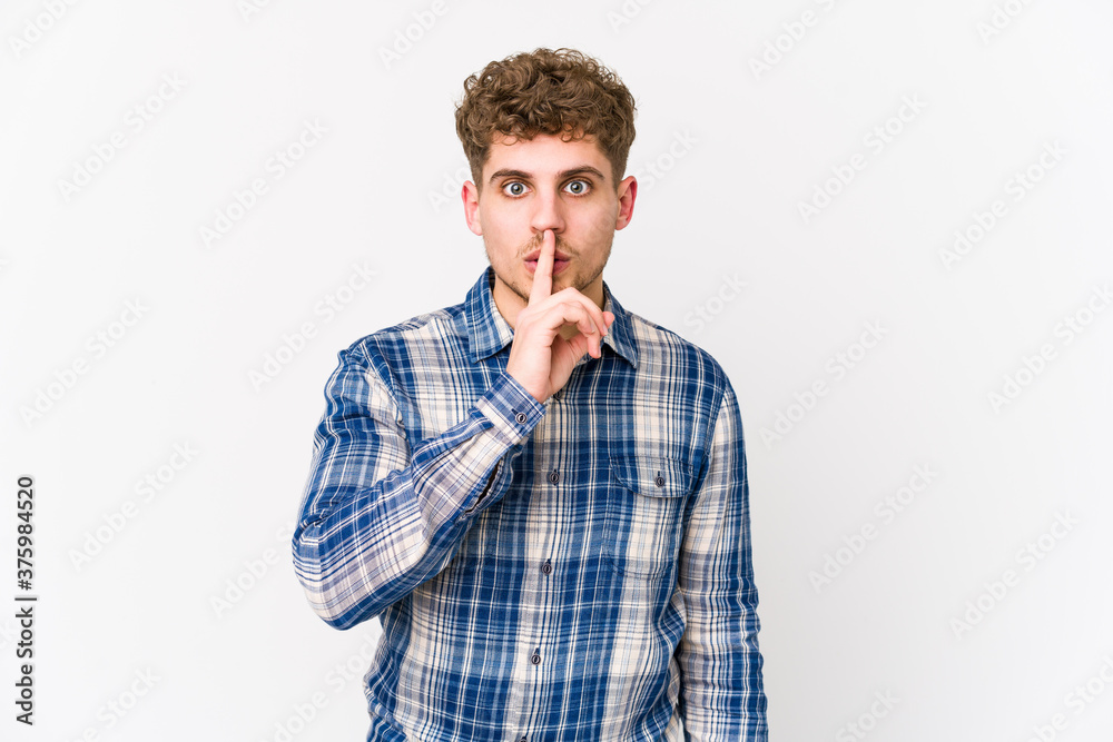 Young blond curly hair caucasian man isolated keeping a secret or asking for silence. Young blond curly hair caucasian man isolated keeping a secret or asking for silence.
