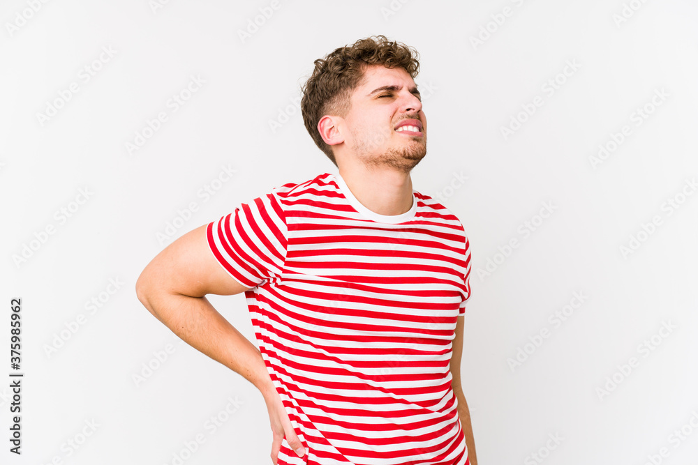 Young blond curly hair caucasian man isolated suffering a back pain. Young blond curly hair caucasian man isolated suffering a back pain.