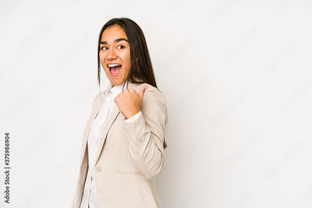 Young woman isolated on a white background points with thumb finger away, laughing and carefree. Young woman isolated on a white background points with thumb finger away, laughing and carefree.