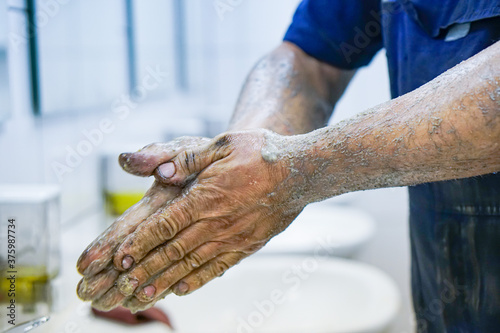 фотографія the mechanic washes his dirty hands after a working day
