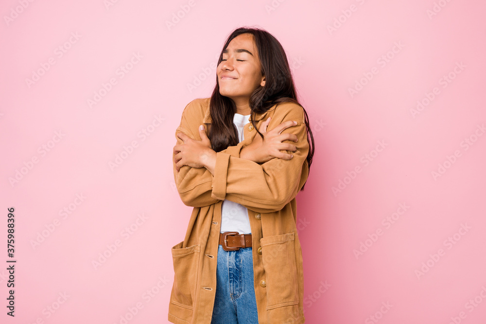 Young mixed race indian woman isolated hugs, smiling carefree and happy. Young mixed race indian woman isolated hugs, smiling carefree and happy.